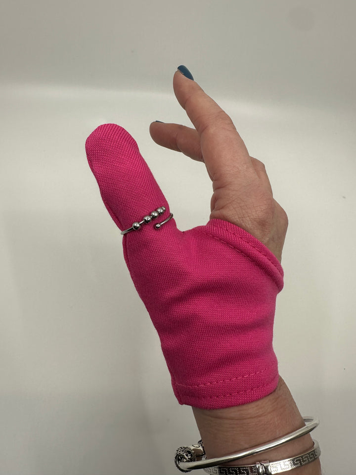 Hand wearing a pink finger sleeve with a plain background wearing a fidget ring